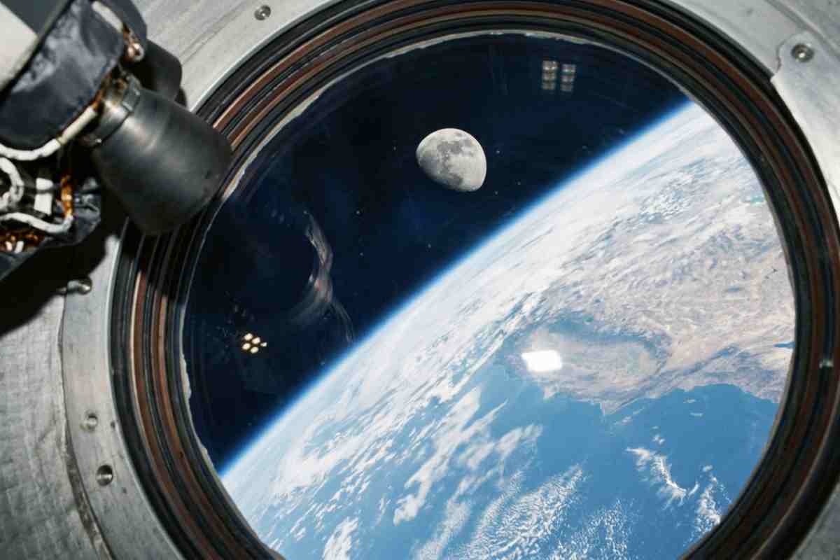 "Vista della Terra e della Luna dall'oblò della capsula Orion: missione NASA Artemis 2 prima del rientro record.