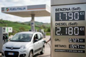 Totem prezzi carburanti 11 aprile 2026: Benzina 1,790 €/l, Diesel 2,180 €/l, GPL 0,727 €/l, Metano 1,547 €/kg. Auto Fiat Panda in rifornimento presso stazione di servizio FuelItalia. Foto realistica e aggiornata per news sui costi benzina e gasolio oggi in Italia.